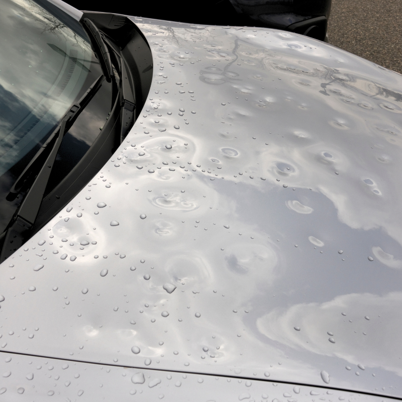 Closeup of severe hail damage on a car hood with multiple dents, representing hail repair services offered by Core Collision in Kyle - Buda - Georgetown