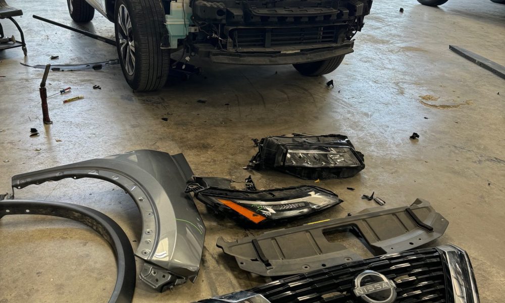 Nissan SUV with front end disassembled during a full damage assessment at Core Collision Kyle Buda to identify structural