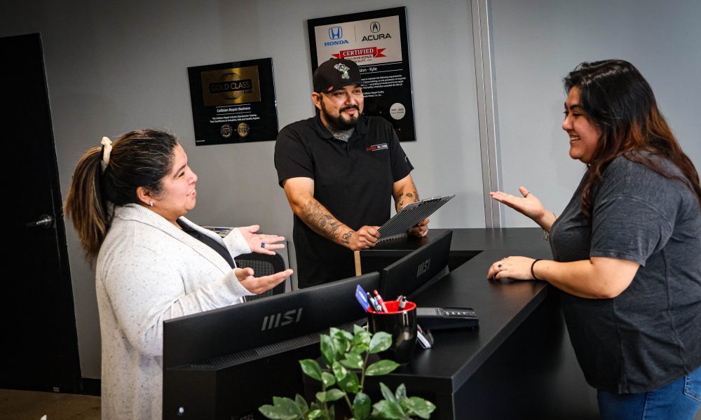 Core Collision team members greet and assist a customer at the front desk of the Kyle, TX collision repair shop.