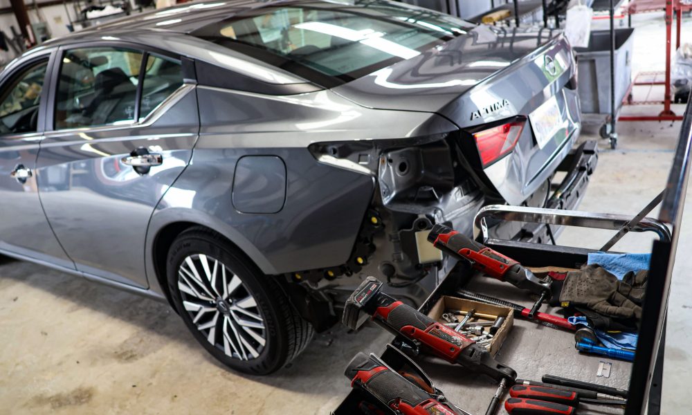 A Nissan Altima undergoing collision repair with the rear bumper removed in the Core Collision repair facility in Kyle, TX.