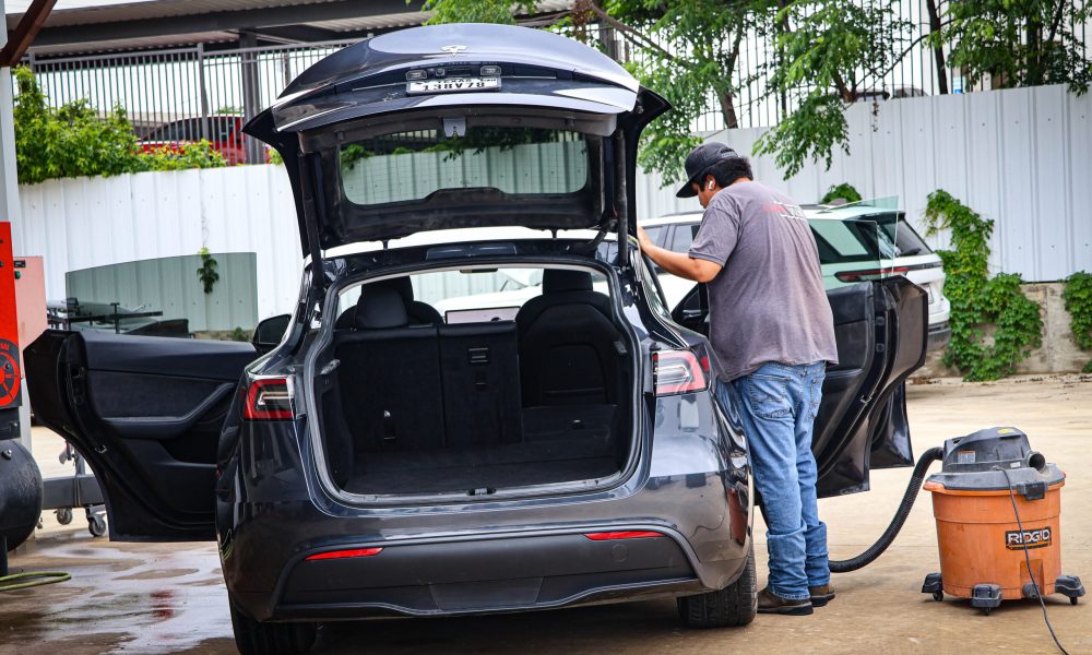 A Core Collision technician performs detailing and a final quality inspection on a Tesla before delivery in Kyle, TX.